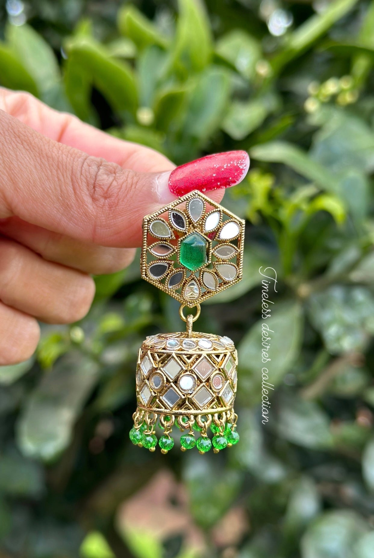 Green Jhumka earrings in mirror