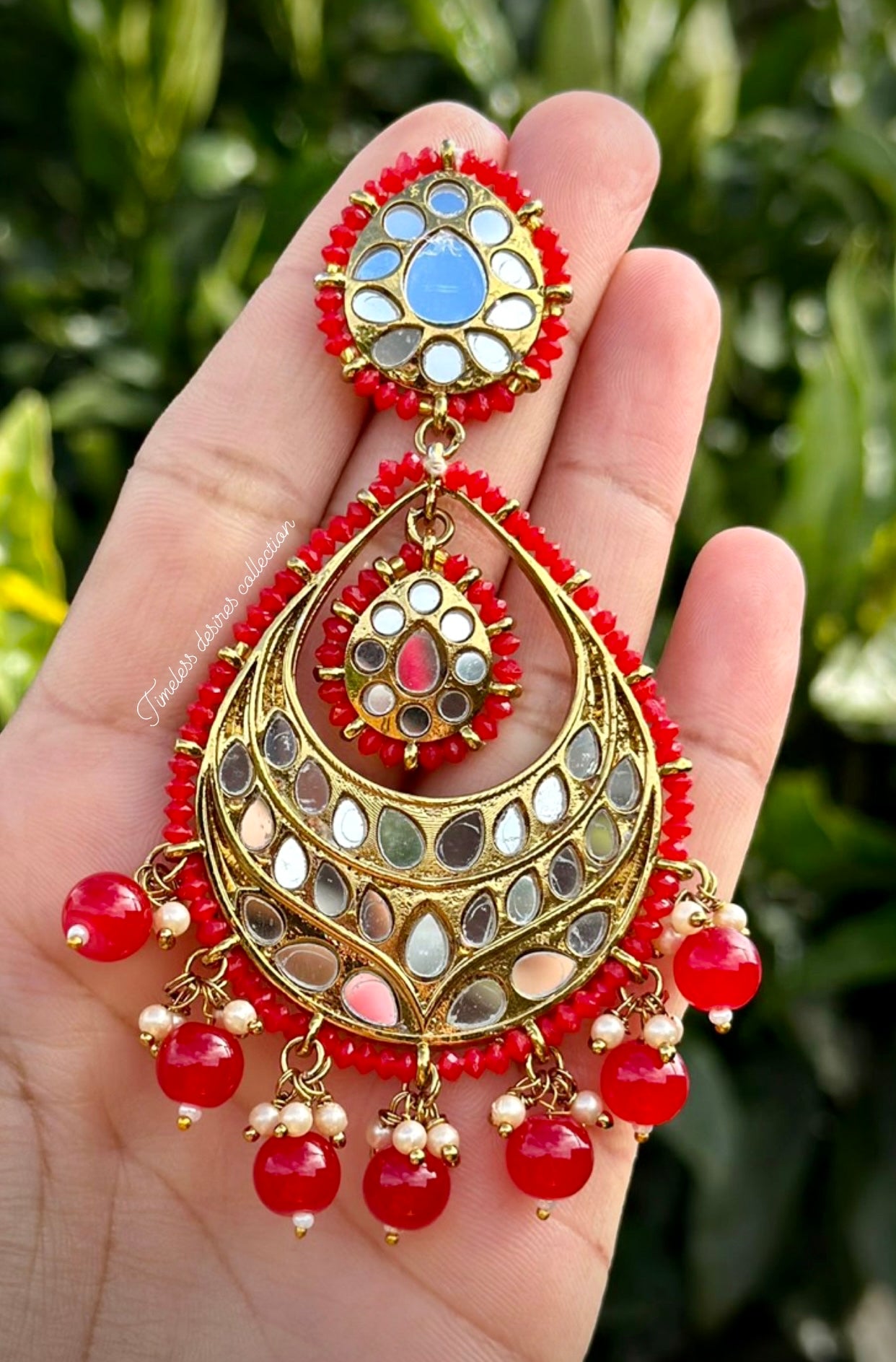 Red earrings in mirror on copper base