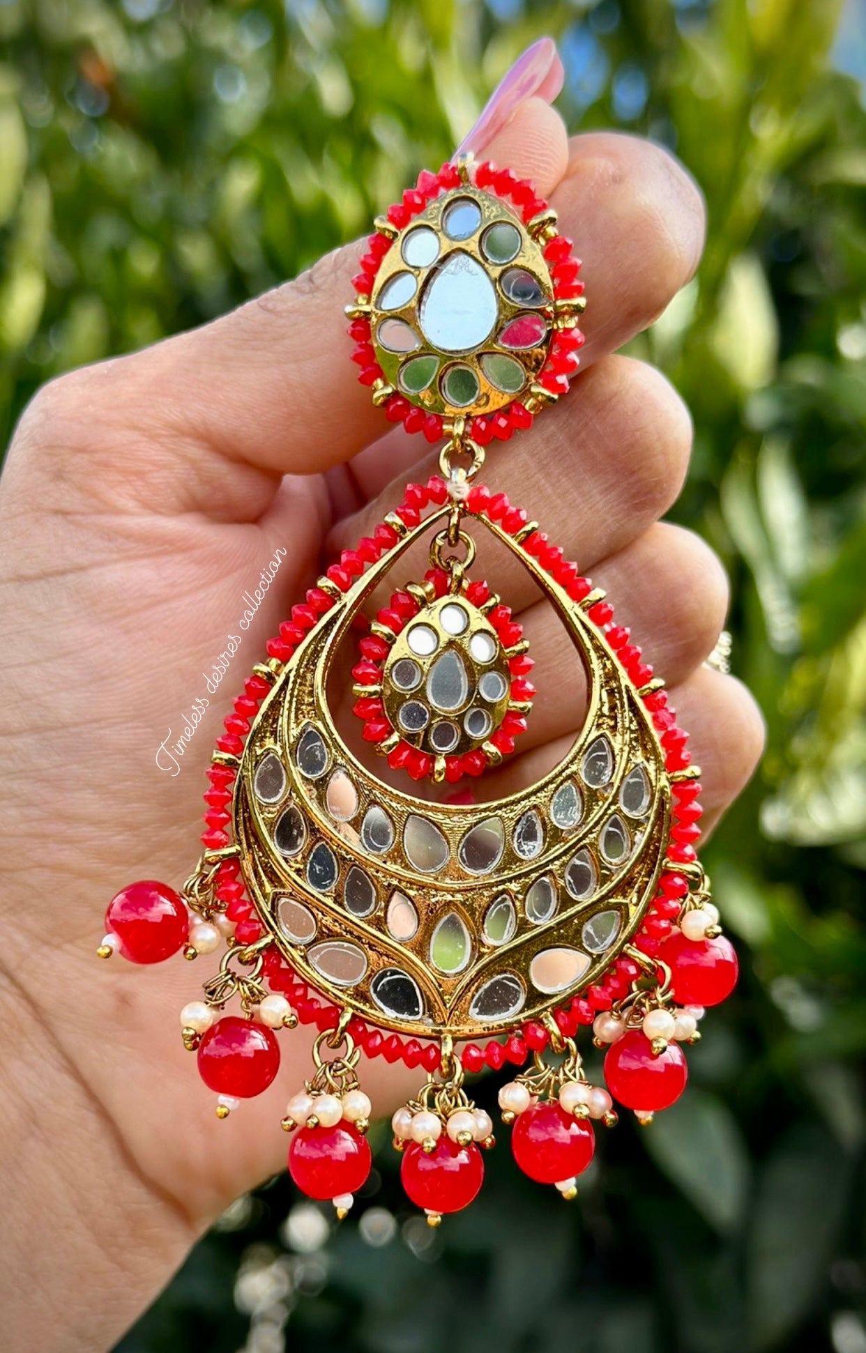 Red earrings in mirror on copper base