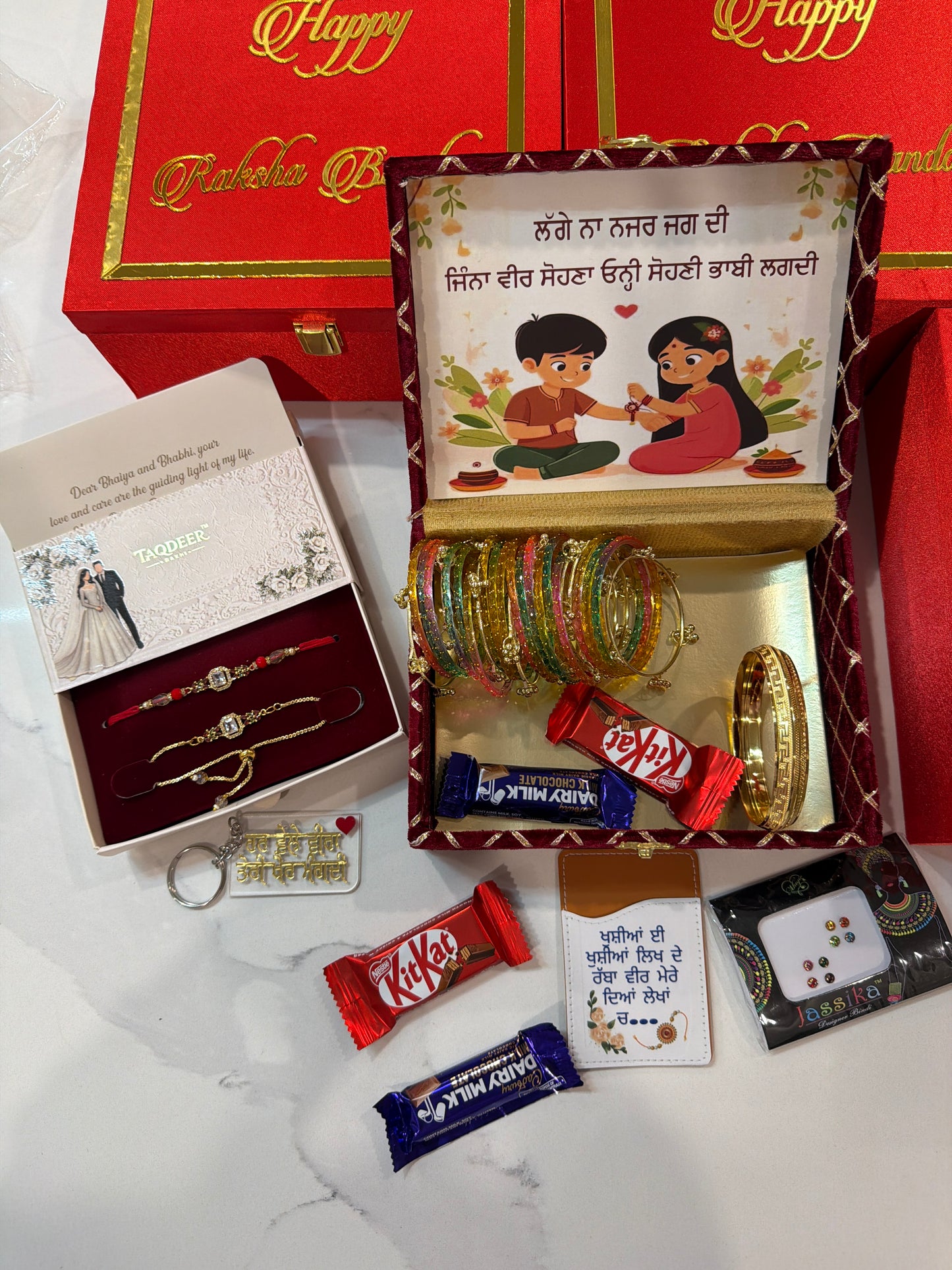 Premium Couple hamper box - No 4 ( includes - customised hamper box , veera bhabi AD rakhi set, chocolates ,gift items- gold look kada for veer, Kashmiri bangles for bhabi -2 hands, key chain ,card holder , bindi pack - note : assorted accessories designs